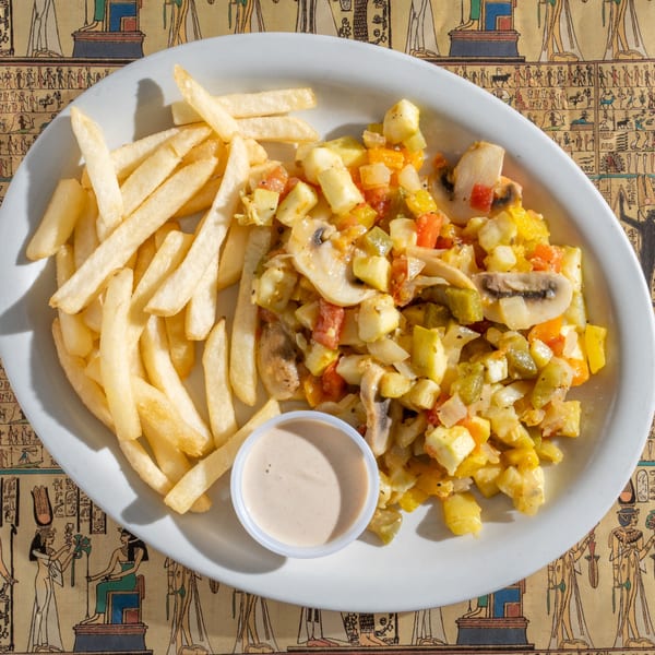 King Tut's Egyptian stir-fry with vegetables, mushrooms, and cheese, served with french fries and sauce.